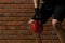 An athlete picks up a red weight to improve the body in a fitness room against a brick wall background