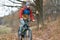 Athlete rides a bicycle in the nature at high speed in autumn