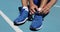 Athlete runner getting ready to run tying shoe laces on stadium running track