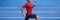 Athlete runner man sprinting in red compression top on run race track panorama. Horizontal banner panoramic crop on blue