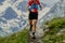 athlete runner running mountain trail skyrunning marathon in background snowy peaks