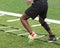 Athlete running ladder drills on turf field in cleats