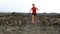 Athlete running - male runner exercising outdoors. Man triathlete running fast on lava trail living healthy active