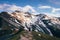 Athlete runs on a footpath on the Austrian mountain TÃ¶rlkopf overlooking the highest peak of the Grossglockner with rest of the