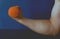 The athlete\'s hand raises an orange kettlebell.