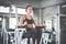 Athlete sporty woman exercising arm on machine builder muscles in fitness gym