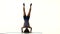 Athlete stands on his head and trains the body. White