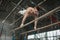 Athlete topless doing exercises on the uneven bars