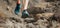 Athlete trail running in the mountains on rocky terrain