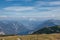 Athlete with white-and-yellow parachute hovers over Mount Krippenstein in upper Austria, enjoying view of valley and rest of the