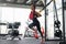 Athlete woman training exercising with suspension system indoor gym. Beautiful caucasian sportive woman do stretching strenght