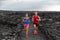 Athletes couple running runners exercising endurance in volcanic landscape extreme terrain. Man runner, Asian woman