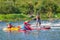 Athletes kayakers during training on whitewater. Man on inflatable stand up paddle board SUP