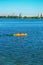 Athletes in kayaks in training near the river fountain in a rainbow of splashes