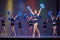 Athletes perform on stage, young cheerleaders perform at the cheerleading championship, girls are holding pompons, hands raised up