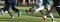 Athletes performing running drills on a turf field on a cold day