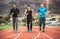 Athletes practicing a run on athletics stadium track.