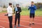 Athletes practicing a run on athletics stadium track, having break