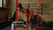 Athletic active fit black female doing one-arm dumbbell row on bench at gym