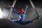 Athletic aerial circus artist with redhead in blue costume dancing in the air with balance