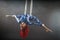 Athletic aerial circus artist with redhead in blue costume dancing in the air with balance