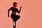 Athletic african american lady warming up before running, training on peach neon studio background, copy space