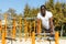 Athletic african american male performs warm-up exercises at chin-up bar