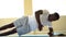 Athletic African American man balancing on one arm while doing side plank exercise on mat in gym