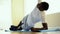 Athletic African American man balancing on one arm while doing side plank exercise on mat in gym