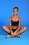 Athletic african fitness woman sits cross legged