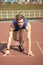 Athletic bearded man with muscular body stretching on running track