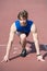 Athletic bearded man with muscular body stretching on running track