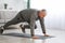 Athletic bearded senior man doing exercises at home