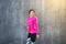 Athletic black girl with bottle of water over grey background