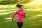 Athletic black girl jogging by public park