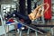 Athletic blonde woman using press machine in gym