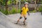 Athletic boy in helmet and knee pads learns to skateboard with in a skate park. Children education, sports