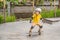 Athletic boy in helmet and knee pads learns to skateboard with in a skate park. Children education, sports