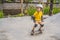 Athletic boy in helmet and knee pads learns to skateboard with in a skate park. Children education, sports