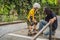 Athletic boy learns to skateboard with a trainer in a skate park. Children education, sports