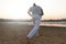 Athletic capoeira performer making movements on the beach