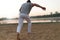 Athletic capoeira performer making movements on the beach