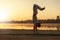 Athletic capoeira performer workout training on the beach sunris