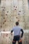 Athletic climber with physical disability standing in front of wooden rock wall