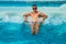 Athletic confident man relaxing in pool jacuzzi outdoor at spa resort enjoying luxury life. Success, healthy lifestyle, body care