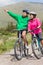 Athletic couple on a bike ride wearing hooded jumpers with man p