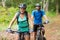 Athletic couple cycling in forest