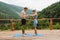 Athletic couple doing yoga exercise on terrace in mountains
