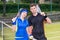 Athletic couple of tennis players holding a racket and a ball o