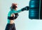 Athletic female fighter boxing on punching bag of tires in studio in neon light. Mixed martial arts poster